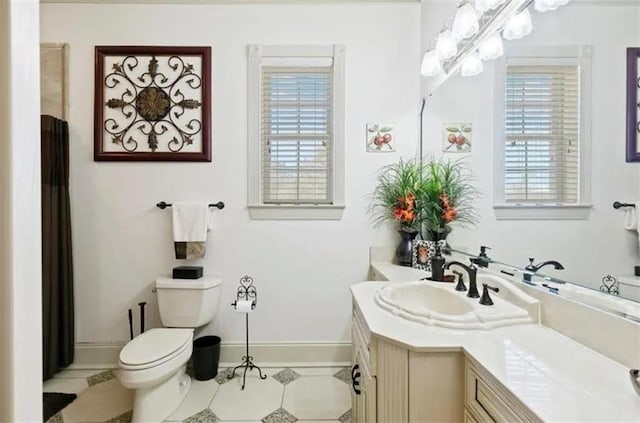 bathroom with baseboards, toilet, tile patterned floors, and vanity