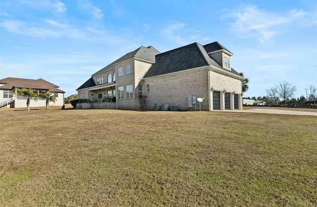 view of side of home with driveway, a garage, and a yard