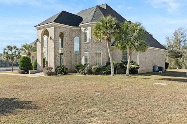 exterior space featuring brick siding and a lawn