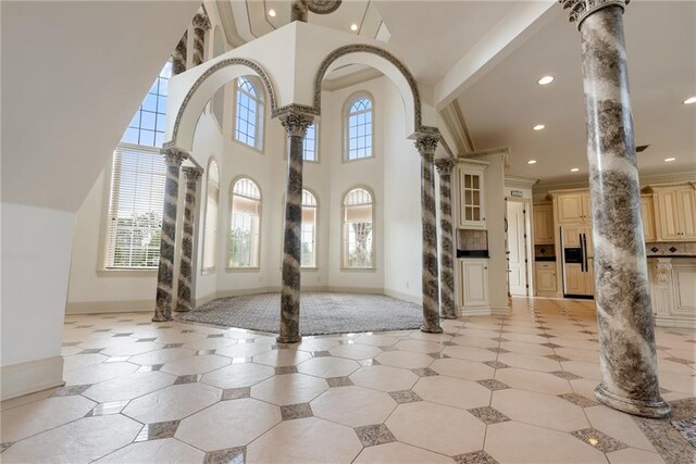 foyer with ornate columns, ornamental molding, recessed lighting, and plenty of natural light