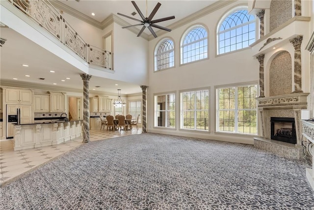 living room with recessed lighting, decorative columns, ornamental molding, a ceiling fan, and a fireplace