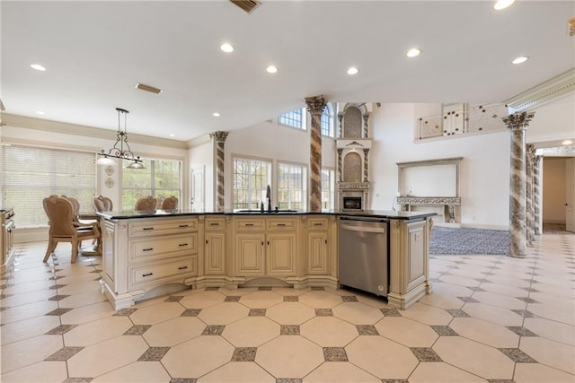 kitchen with cream cabinetry, crown molding, dark countertops, a sink, and stainless steel dishwasher