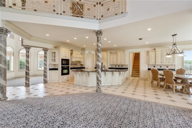 kitchen with a breakfast bar area, backsplash, cream cabinets, dark countertops, and black appliances