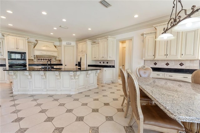kitchen with custom exhaust hood, a sink, cream cabinets, a breakfast bar area, and black appliances