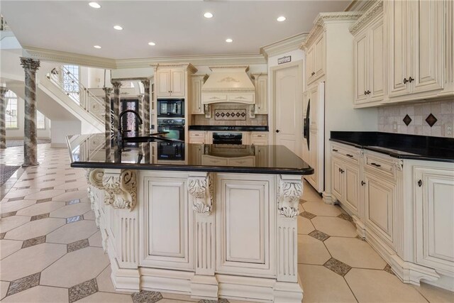 kitchen featuring premium range hood, cream cabinetry, dark countertops, and black appliances