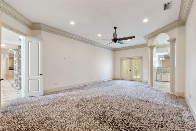 empty room with ornate columns, french doors, carpet floors, visible vents, and a ceiling fan