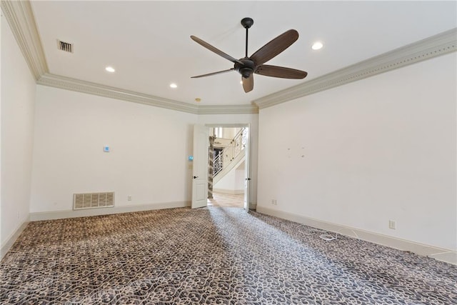 carpeted spare room featuring visible vents, ornamental molding, ceiling fan, and stairway