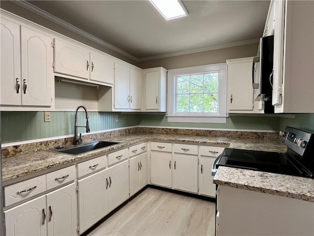 kitchen with white cabinets, stainless steel appliances, crown molding, light wood-type flooring, and a sink