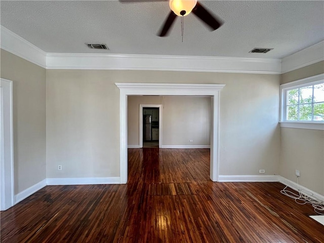 spare room with a textured ceiling, hardwood / wood-style floors, visible vents, and baseboards