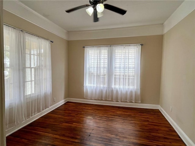 spare room featuring ornamental molding, wood finished floors, a ceiling fan, and baseboards