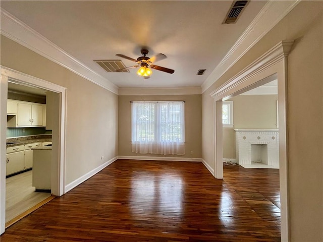 spare room featuring ornamental molding, dark wood-type flooring, and visible vents