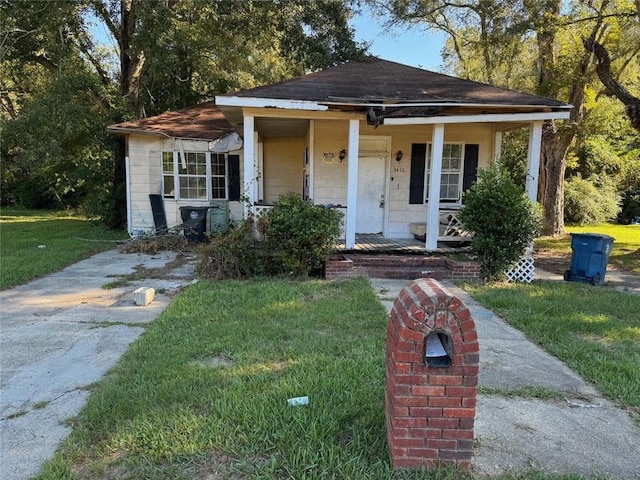 bungalow with covered porch and a front yard