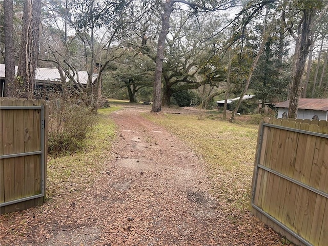 view of road with a gated entry and dirt driveway