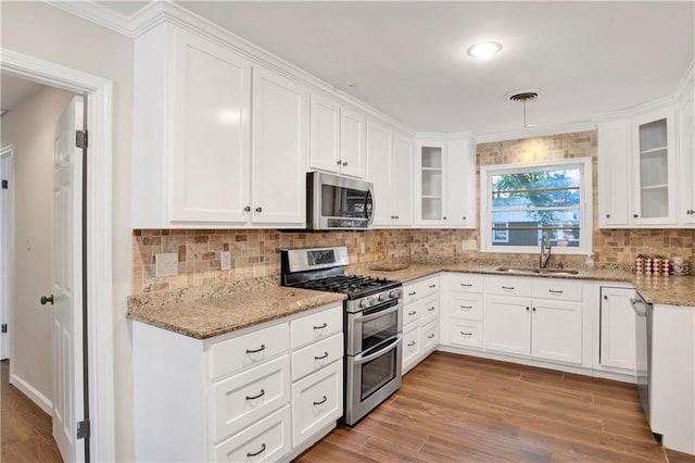 kitchen featuring white cabinets, light stone countertops, sink, light hardwood / wood-style floors, and stainless steel appliances