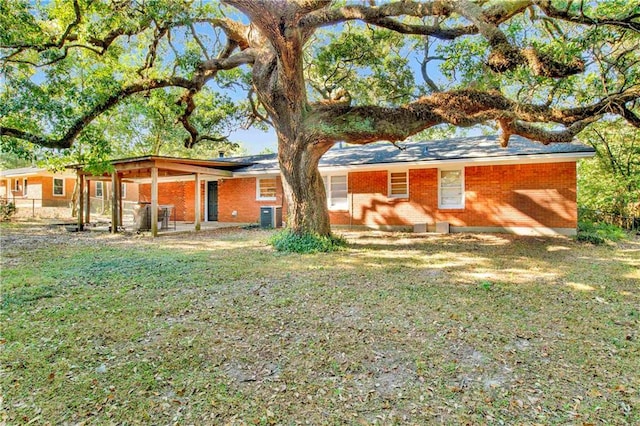 back of house featuring central AC and a yard