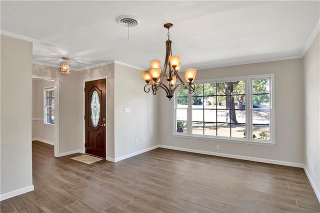 foyer entrance with a notable chandelier, ornamental molding, and dark wood-type flooring