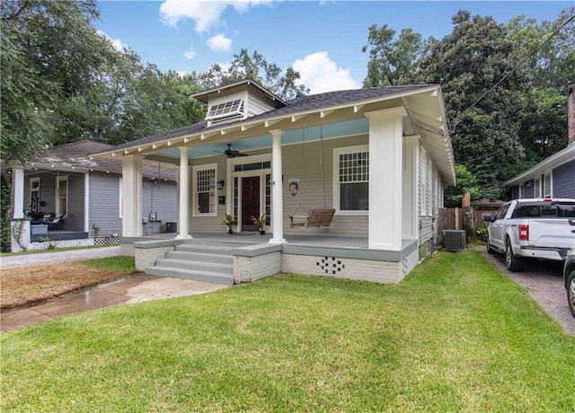 bungalow-style home featuring covered porch, fence, a front lawn, and a ceiling fan
