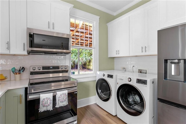 washroom with independent washer and dryer, laundry area, crown molding, baseboards, and light wood-style floors