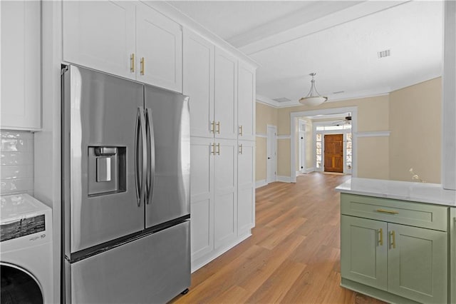 kitchen with stainless steel refrigerator with ice dispenser, light wood-type flooring, white cabinetry, green cabinets, and washer / dryer