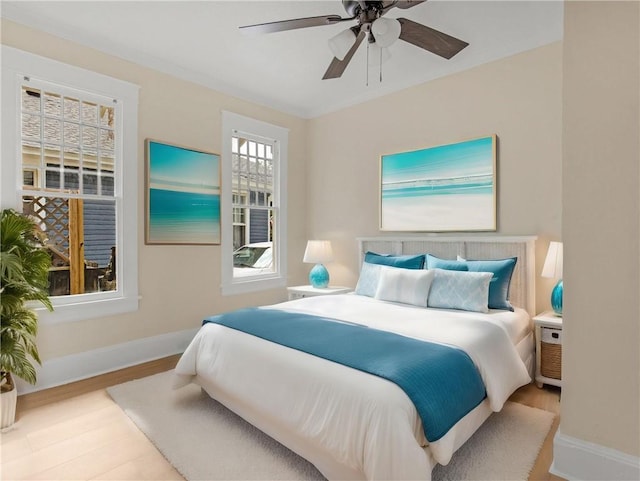 bedroom featuring baseboards, ceiling fan, and wood finished floors