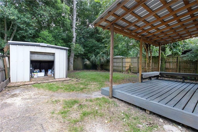 view of yard featuring an outbuilding, a wooden deck, a fenced backyard, and a storage unit