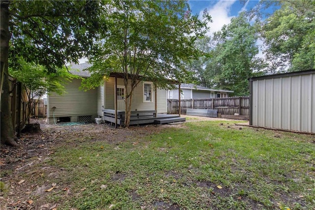 back of house with a lawn, a deck, and a fenced backyard