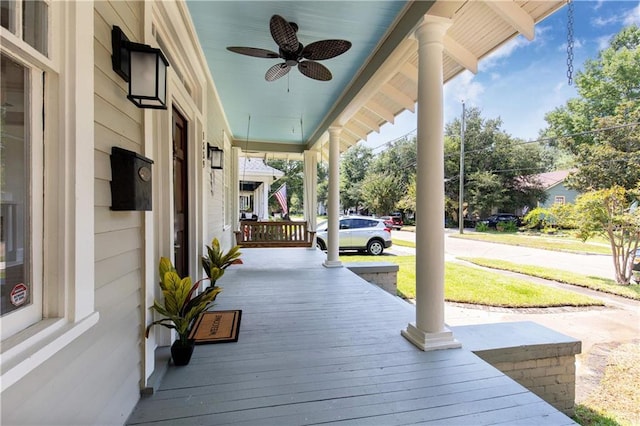 wooden terrace with a porch and ceiling fan