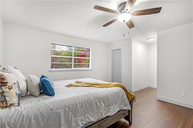 bedroom with hardwood / wood-style flooring, ceiling fan, and a closet