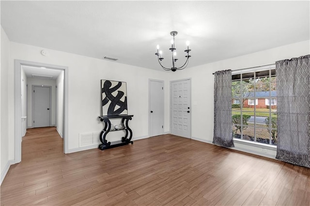 interior space with an inviting chandelier and hardwood / wood-style flooring