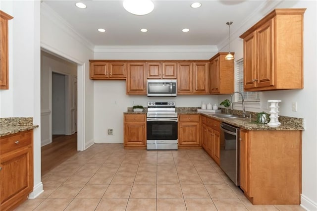 kitchen with a sink, dark stone counters, brown cabinets, and appliances with stainless steel finishes