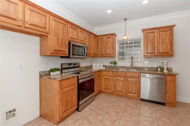 kitchen featuring a sink, dark stone counters, ornamental molding, and stainless steel appliances