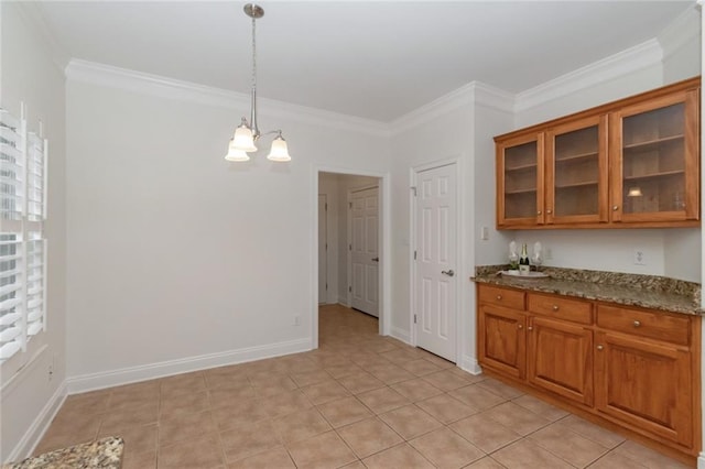 kitchen with crown molding, glass insert cabinets, brown cabinets, and dark stone counters