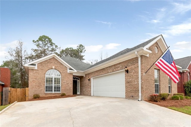 ranch-style home featuring brick siding, concrete driveway, a garage, and fence