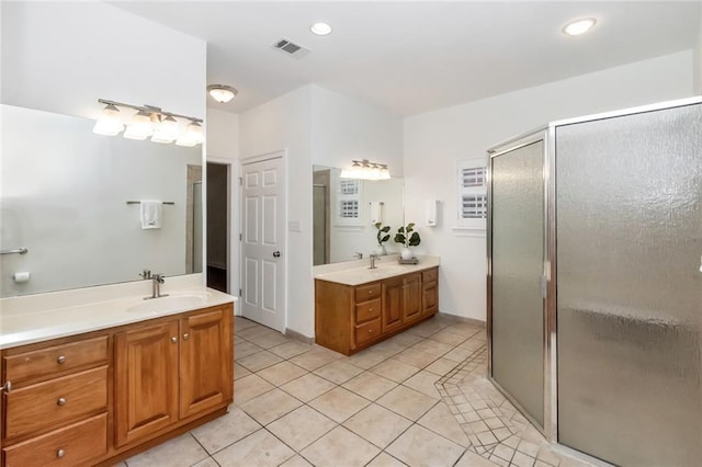 full bathroom with a shower stall, two vanities, and a sink