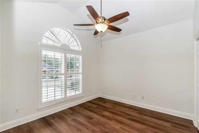 spare room with dark wood finished floors, a ceiling fan, and baseboards