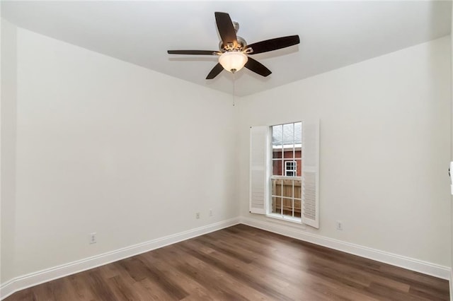 unfurnished room featuring dark wood finished floors, a ceiling fan, and baseboards