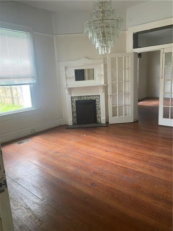 1902 Calmes St, Mobile, AL 36606 - unfurnished living room with wood-type flooring, a fireplace, and a chandelier