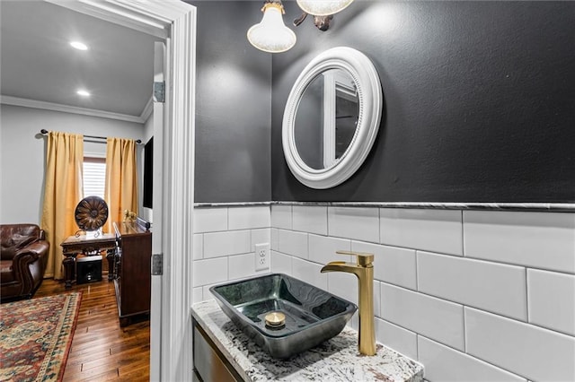 bathroom featuring sink, wood-type flooring, and ornamental molding