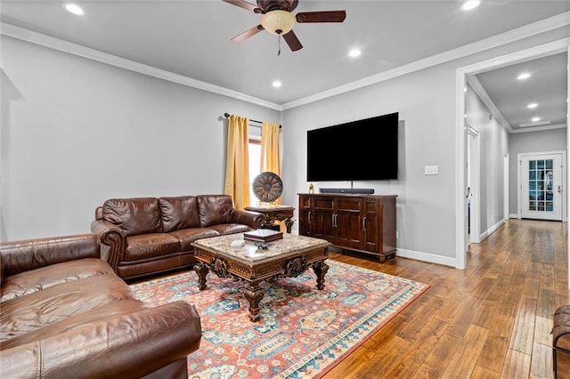 living room featuring crown molding, ceiling fan, and light wood-type flooring