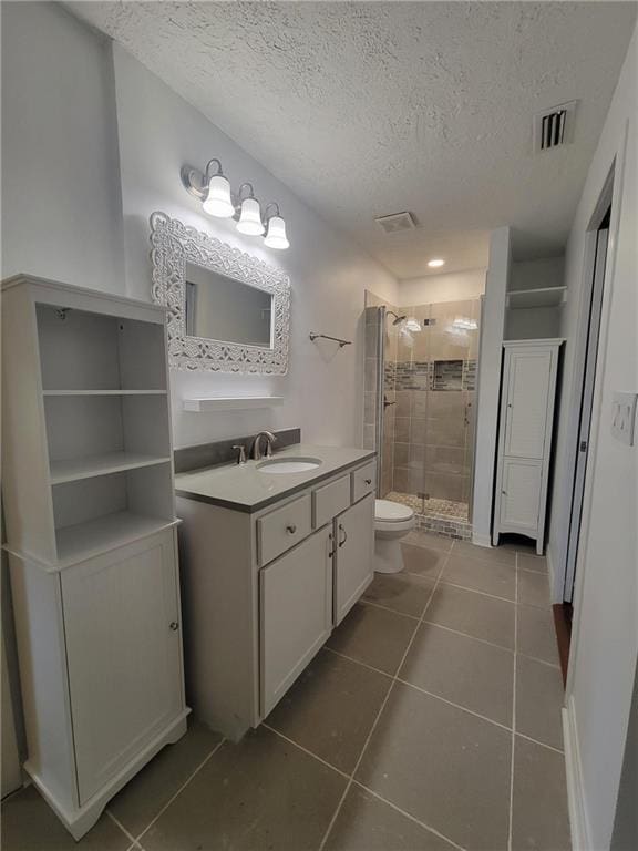 2544 Buckboard Ct, Mobile, AL 36695 - bathroom with a textured ceiling, vanity, toilet, tile patterned flooring, and a shower stall