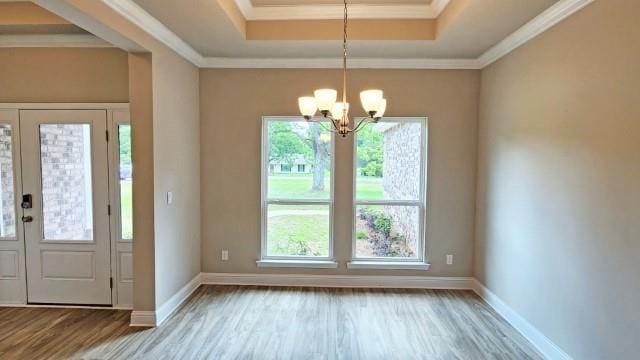 foyer with french doors, light hardwood / wood-style floors, ornamental molding, and an inviting chandelier