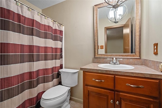 bathroom with vanity, toilet, and a textured ceiling