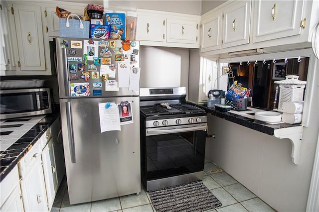 612 Summerland Dr, Mobile, AL 36617 - kitchen with stainless steel appliances, light tile patterned floors, white cabinets, and tile countertops