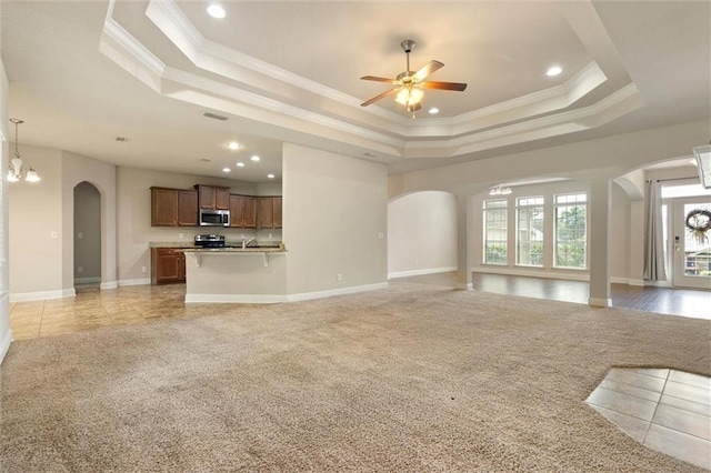 2151 Elliott Ct, Mobile, AL 36695 - unfurnished living room with a tray ceiling, arched walkways, light colored carpet, baseboards, and crown molding
