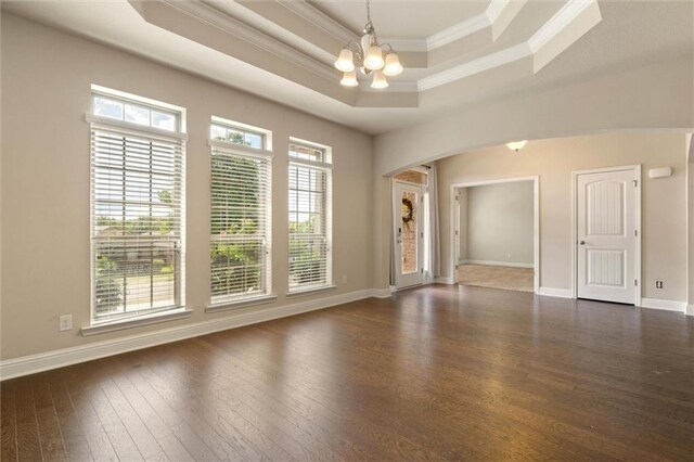 2151 Elliott Ct, Mobile, AL 36695 - empty room featuring crown molding, a raised ceiling, a chandelier, dark wood-style flooring, and arched walkways