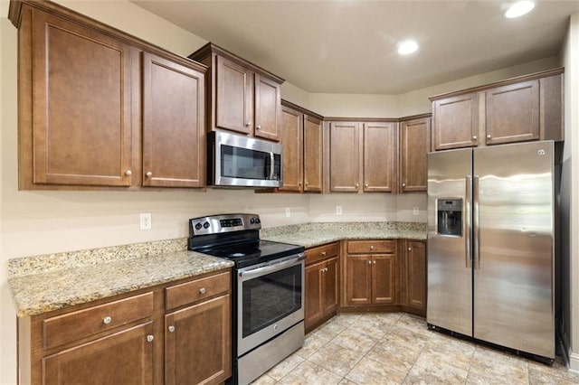 2151 Elliott Ct, Mobile, AL 36695 - kitchen with stainless steel appliances, light stone counters, recessed lighting, and light tile patterned floors