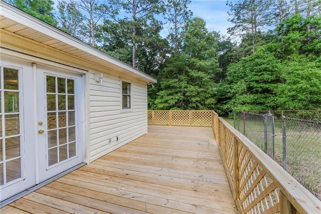 wooden terrace featuring fence and french doors