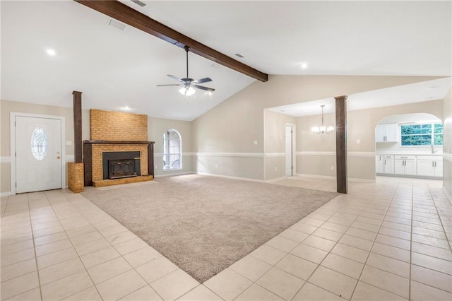 unfurnished living room featuring light tile patterned flooring, light colored carpet, ceiling fan with notable chandelier, baseboards, and vaulted ceiling with beams