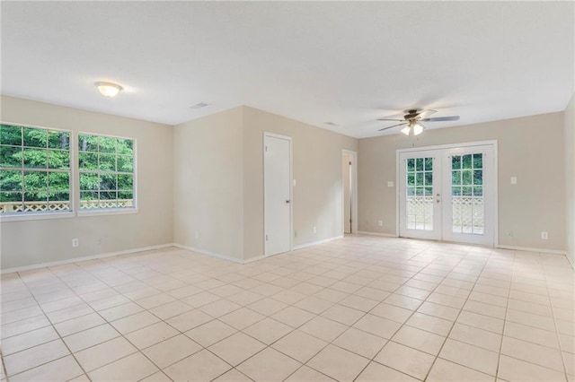 spare room with french doors, a ceiling fan, baseboards, and light tile patterned floors