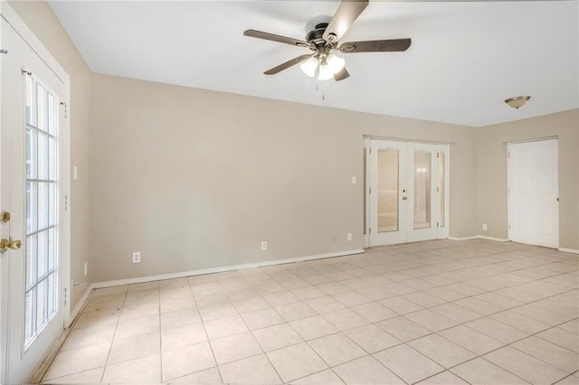 spare room with a healthy amount of sunlight, baseboards, a ceiling fan, and french doors
